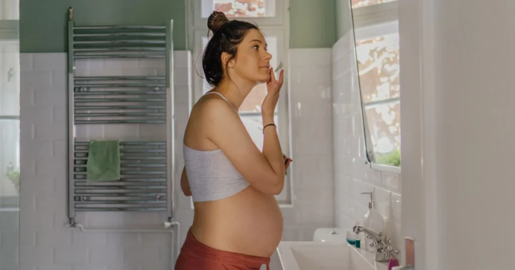 Pregnant woman applying skincare