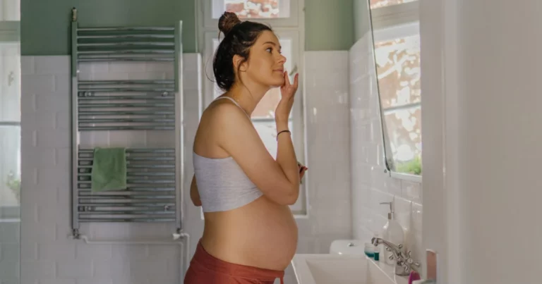 Pregnant woman applying skincare